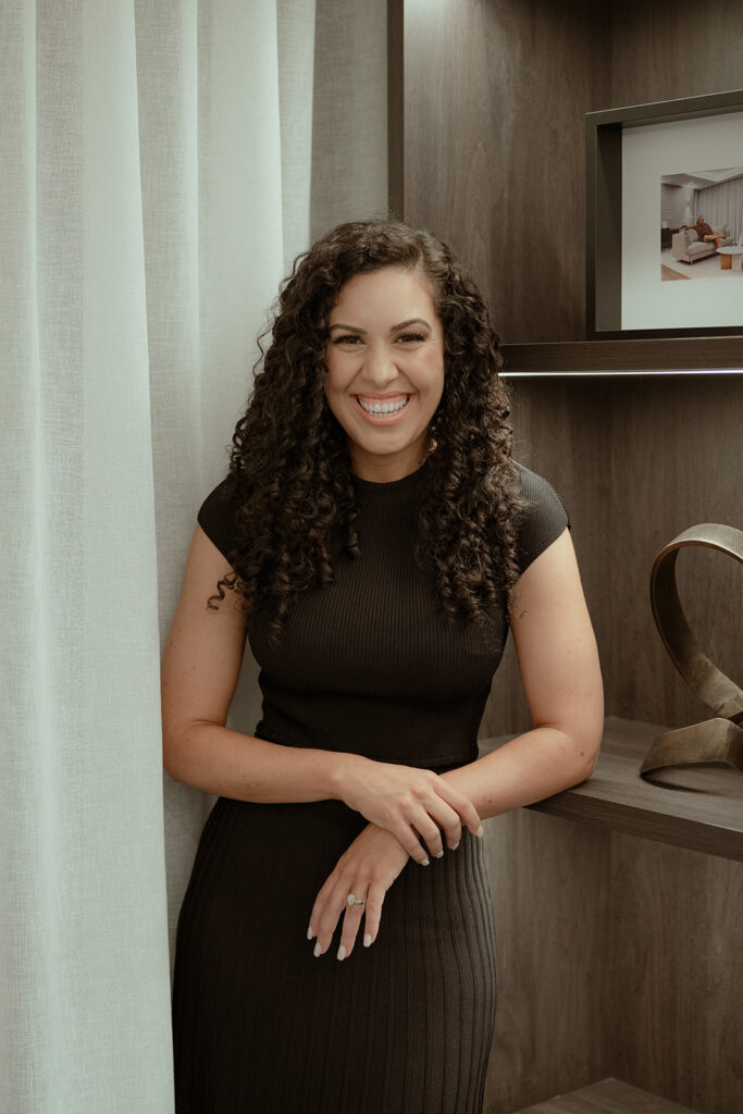 Woman in black dress smiling at the camera
